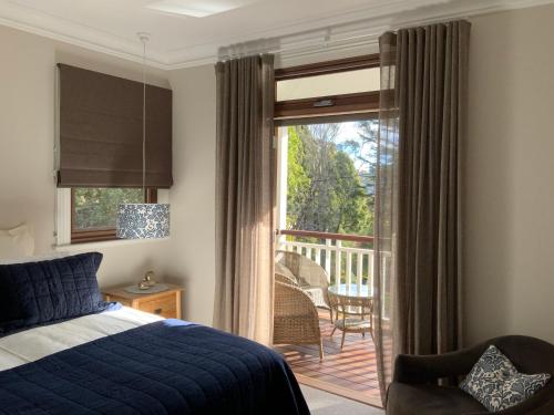 a bedroom with a bed and a sliding glass door at La Casétta in Leura