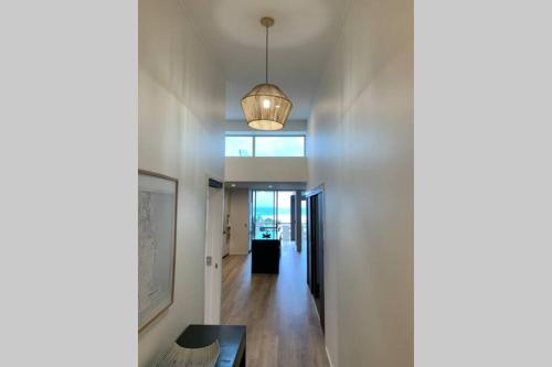 a hallway with a white wall and a pendant light at 338 Paradiso Kingscliff Beach in Kingscliff