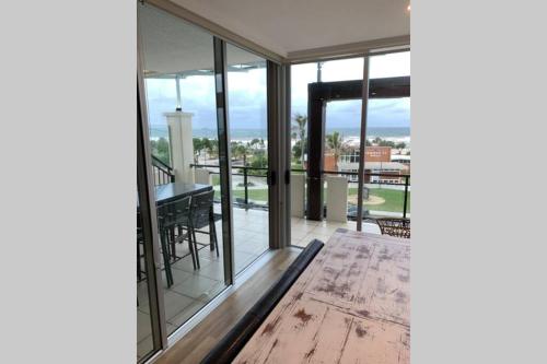 a living room with glass doors and a table at 338 Paradiso Kingscliff Beach in Kingscliff