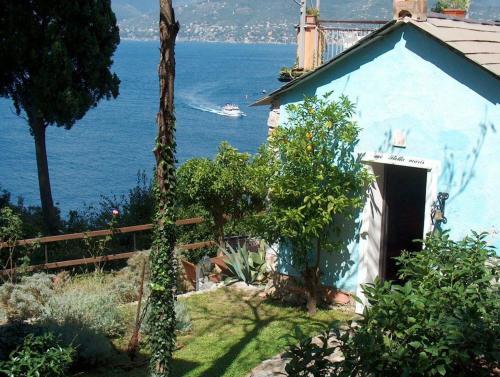 a blue house with the ocean in the background at Stella Maris Resort in Camogli
