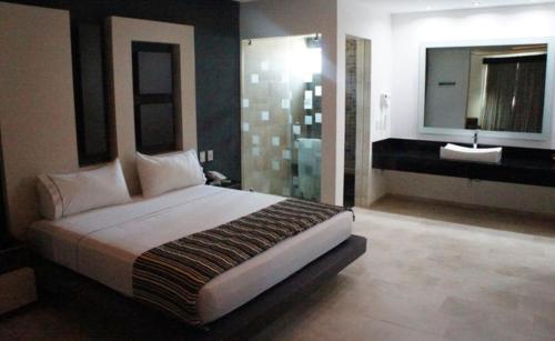 a bedroom with a large bed and a bathroom at Motel Casablanca in Guadalajara