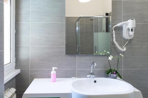 bagno con lavandino e specchio di Appartamento Sestante a Lido di Ostia