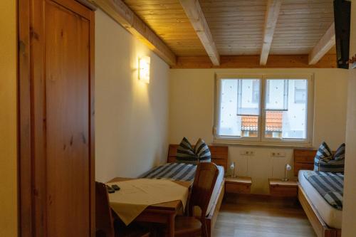 um quarto com duas camas e uma mesa e uma janela em Gästehaus Familie John em Veitsbronn