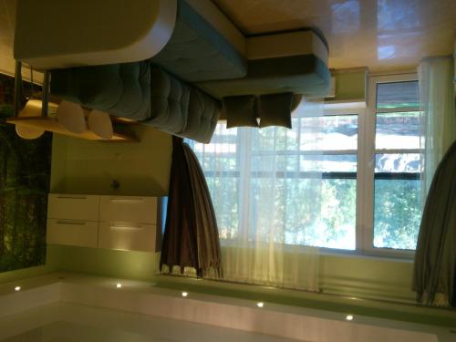 ein Schlafzimmer mit einem Fenster, einem Bett und einem Waschbecken in der Unterkunft Pansionaat Valentina in Narva-Jõesuu