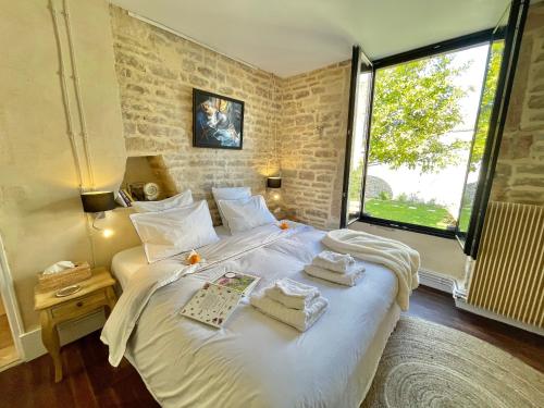 a bedroom with a large white bed with towels on it at MonCoeur, maison et jardin à 700 m des Hospices de Beaune in Beaune