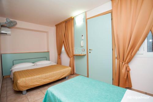 a bedroom with two beds and a sliding glass door at Villaggio Albatros Resort in Lesina