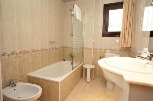 a bathroom with a tub and a sink and a toilet at Hotel & SPA Niunit in Ordino