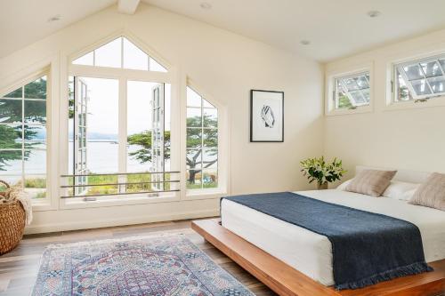 a bedroom with a large bed and large windows at A little piece of heaven... in Half Moon Bay