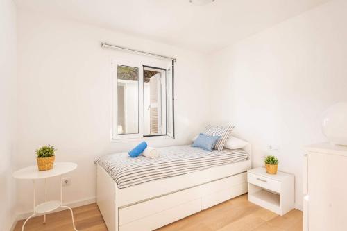 a white room with a bed and a window at Villa Ca Na Margarita by Villa Plus in Cala Blanca