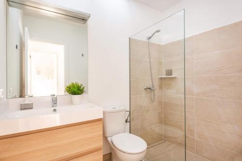 a bathroom with a shower and a toilet and a sink at Villa Ca Na Margarita by Villa Plus in Cala Blanca
