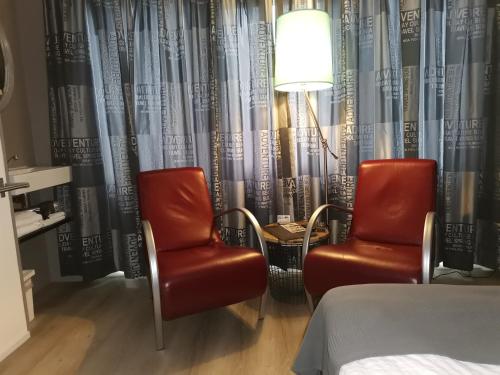 zwei Stühle und eine Lampe in einem Hotelzimmer in der Unterkunft B&B Bovenweg in Rhenen