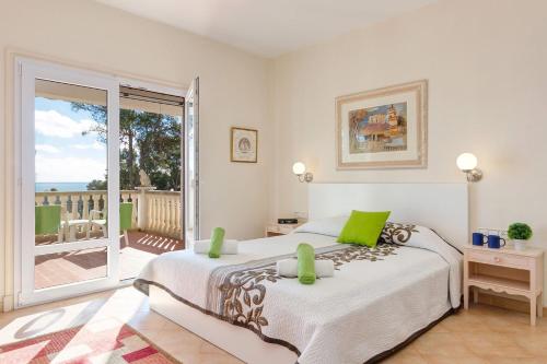 a bedroom with a large bed and a balcony at Villa Leona by Villa Plus in Santo Tomás