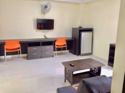 a living room with orange chairs and a desk at Pangviman Residence in Ban Prong Phra Bat Nok (1)