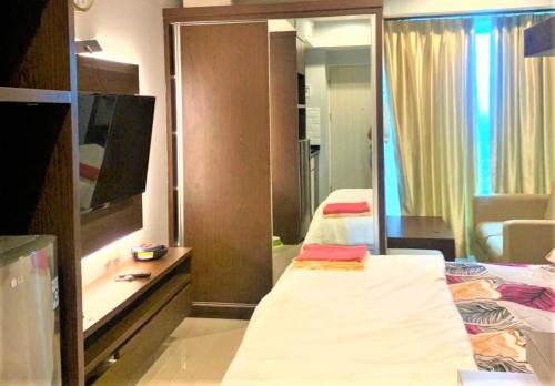 a hotel room with two beds and a mirror at Grand Kamala Lagoon by Veeroom in Pekayon Satu