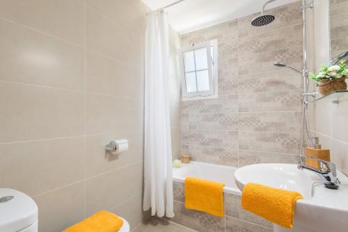Un baño con bañera, lavabo e inodoro. en Villa San Jose by Villa Plus, en Cala'n Porter