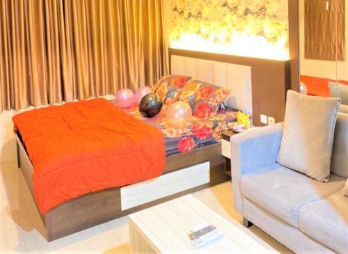 a bedroom with a bed and a couch and balloons at Grand Kamala Lagoon by Veeroom in Pekayon Satu