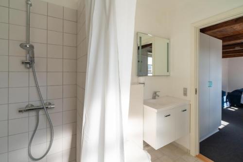 a bathroom with a shower curtain and a sink at Klitmøller Badehotel in Klitmøller