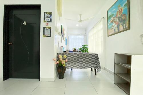 ein Esszimmer mit einem Tisch und einer schwarzen Tür in der Unterkunft OYO Home 90230 Dh Residence in Kota Belud
