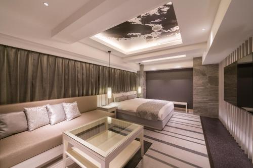 a hotel room with a couch and a bed at Hotel Karuta -Love hotel in Tokyo