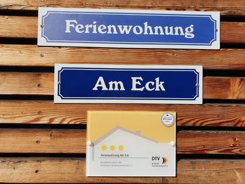 zwei Schilder an einer Holzwand mit einem Schild für einen Ausgang in der Unterkunft Ferienwohnung am Eck in Amorbach