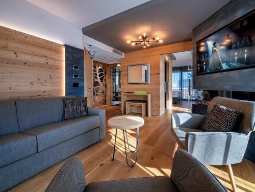 a living room with a couch and a tv at Sporthotel Rosatti in Dimaro