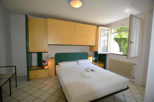 リニャーノ・サッビアドーロにあるLignano Pineta exclusivのベッドルーム(大きな白いベッド1台、窓付)