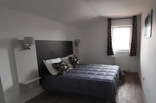 a bedroom with a bed with pillows and a window at Goélia Les Chalets des Pistes in Combloux