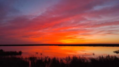 a sunset over a body of water with the sky at Hostal Athlanta in Villalpando