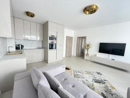 a white living room with a couch and a tv at New Luxury City centre apartment with panoramic view, free parking in Bratislava