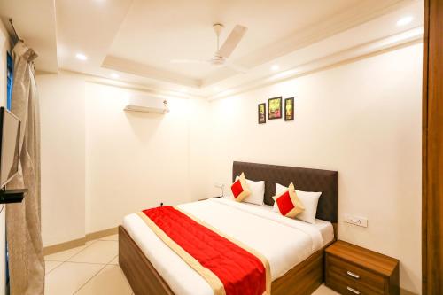 a bedroom with a bed with red and white pillows at FabHotel La Paz Stay B&B in New Delhi