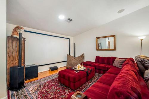 a living room with a red couch and a large screen at Beautiful Scottsdale Escape Heated Pool, Spa, & Putting Green in Phoenix