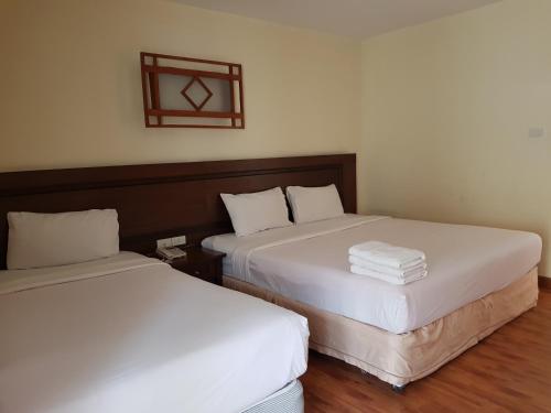 two beds sitting next to each other in a room at Pangviman Place Resotel SHA Plus in Chiang Mai