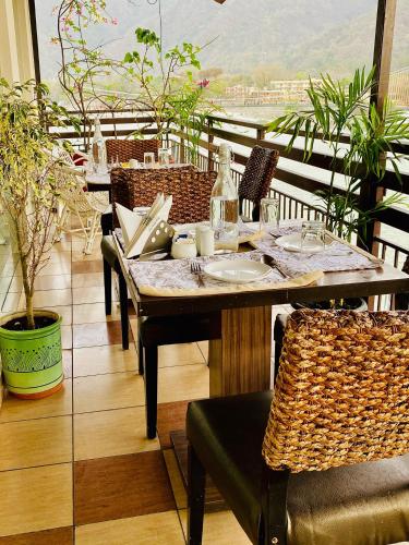 a table and chairs sitting on a balcony with a view at Sanskriti Vedic Retreat in Rishīkesh