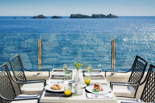 a table with food and a view of the ocean at Royal Neptun Hotel in Dubrovnik