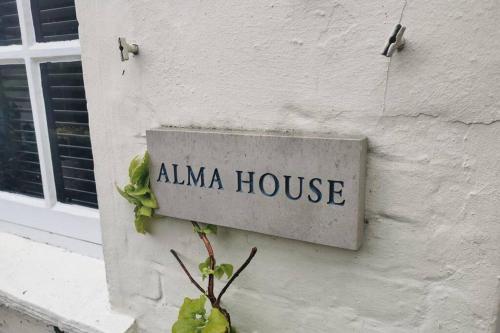 Znak na którym jest napisane "Dom Almy" na boku budynku w obiekcie Alma House w mieście Marlborough