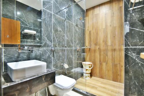 a bathroom with a white toilet and a sink at Hotel Vacation Inn in Amritsar