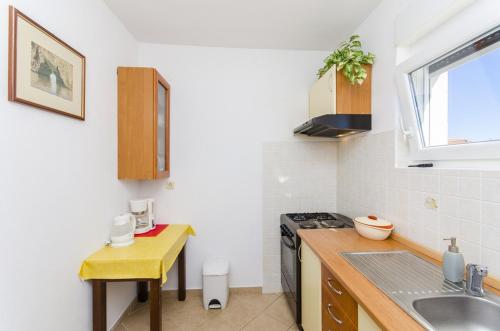 Il comprend une cuisine équipée d'un évier et d'une cuisinière. dans l'établissement Apartment in Stari Grad (Hvar) with Balcony, Air condition, WIFI, Dishwasher (3695-1), à Stari Grad