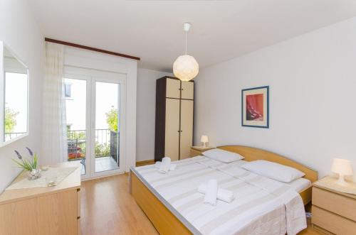 biała sypialnia z dużym łóżkiem i oknem w obiekcie Apartment in Stari Grad (Hvar) with Balcony, Air condition, WIFI, Dishwasher (3695-1) w mieście Stari Grad
