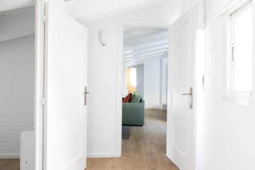 a hallway with white doors and a couch at Aspasios Calle Mayor Apartments in Madrid