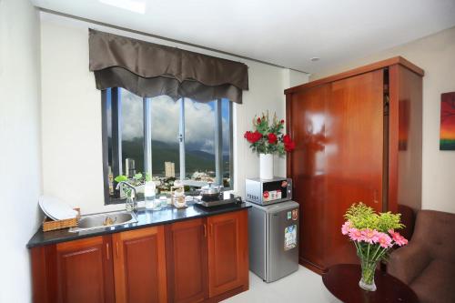 een keuken met een spoelbak en een raam bij Son Tra Green Hotel & Apartment in Da Nang