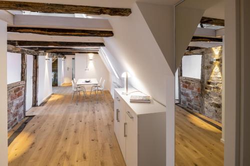 een zolderverbouwing van een gebouw met een tafel en stoelen bij Michaelis Suite - Schrangen-Suites-1389 in Lüneburg