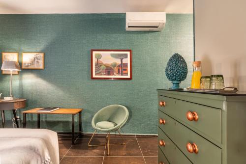 a bedroom with a bed and a chair next to a dresser at Il Giardino di Ballarò Boutique B&B in Palermo