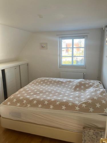 a bed in a bedroom with a window at Privates Domizil auf Sylt in Strandnähe in Westerland