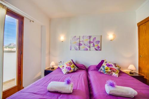 a bedroom with a purple bed with two pillows at Ideal Property Mallorca - Concha in Port d'Alcudia