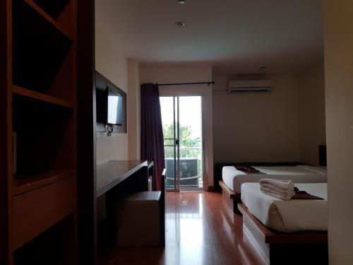a hotel room with two beds and a window at Pangviman Place Resotel SHA Plus in Chiang Mai