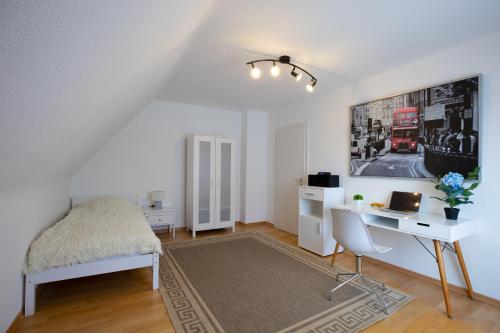 Schlafzimmer mit einem Schreibtisch und einem Bett in einem Zimmer in der Unterkunft - Sweet Dreams - Gästeunterkunft Hannover in Hannover