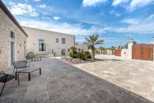a patio with benches in front of a building at Villa Ida - IsulaTravel in Frigintini