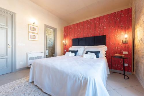 a bedroom with a large bed with a red wall at Villa Ida - IsulaTravel in Frigintini