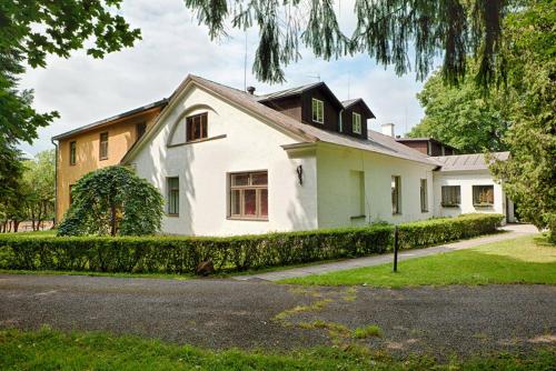 a large white house with a driveway at Äksi pastoraadi sviit in Woldi