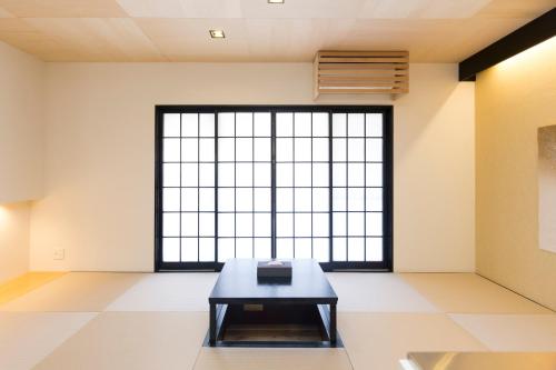 a room with a table in front of a large window at TEMARI in Hakone